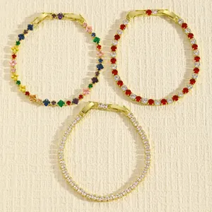 Dettaglio di tre eleganti bracciali tennis in zirconia cubica dorata in vari colori.