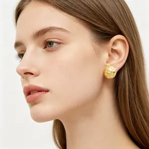 Detailed view of textured gold checkered stud earrings in a minimalist round design.