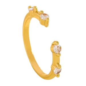 Detailed macro view of a gold open ring set with four sparkling cubic zirconia stones