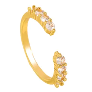 Close-up of golden open ring featuring sparkling white cubic zirconia settings