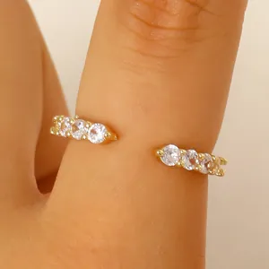Elegant minimalist gold plated open ring with sparkling cubic zirconias on finger