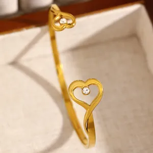 Detailed view of a golden heart-shaped cuff bracelet with a sparkling stone inlay