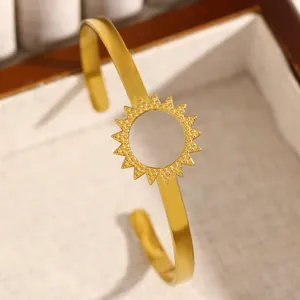 Detailed macro view of golden sun motif on minimalist open cuff bangle