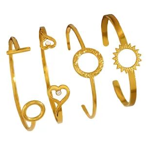 Detailed view of four minimalist golden open bangles with geometric motifs