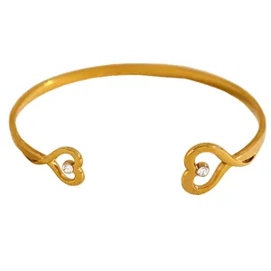 Detailed view of a frosted gold open heart bracelet with sparkling clear crystals