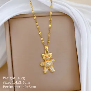 Macro detail of a gold-plated bear pendant necklace with sparkling micro-pave crystals.