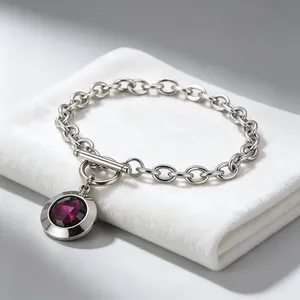 Gros plan d'un bracelet vintage en acier titane avec pendentif cristal violet et boucle OT