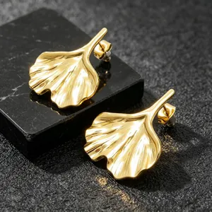 Close-up of 18K gold-plated ginkgo leaf earrings with brushed metal texture detail