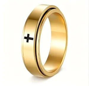 Close-up of rotatable stainless steel ring with black cross design in gold finish