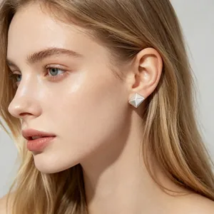 Close-up of minimalist silver geometric square stud earrings on a blonde model