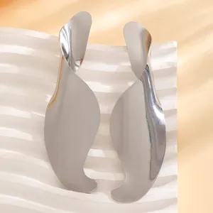 Detailed view of large twisted silver-tone earrings with abstract organic design