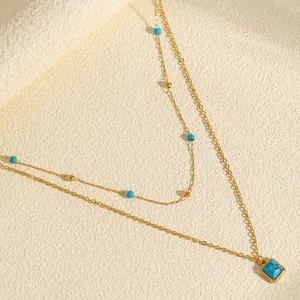 Detailed view of bohemian layered gold necklace with square turquoise pendant and beads
