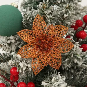 Glitter hollow poinsettia Christmas flower ornament on snowy tree branch