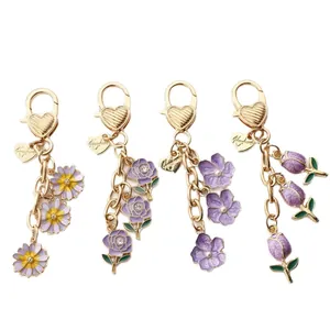 Four stylish floral alloy keychains featuring tulip, rose and daisy designs in gold.
