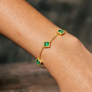 Detail of French vintage gold titanium steel bracelet with square emerald green stones