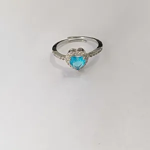 Macro detail of silver adjustable ring with a sparkling blue heart-shaped zircon