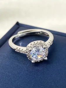 Detailed view of sparkling white zircon halo ring on a premium blue jewelry box