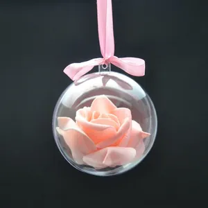Dettaglio di una palla di Natale in acrilico trasparente con una rosa decorativa rosa all'interno