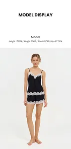 Full body view of model wearing black French-style lace camisole and shorts pajama set