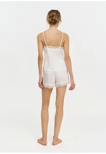 Rear view of elegant French lace pajama set with camisole and shorts in soft pink
