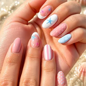Close-up of French press-on nails featuring starfish and polka dot designs in a beach setting.