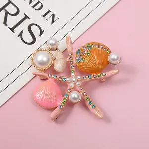Close-up of ocean-themed brooch with starfish, shells, pearls and colorful rhinestones