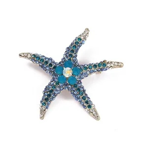 Close-up of blue and clear rhinestone starfish brooch with intricate metal details.
