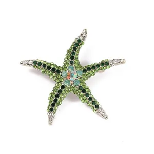 Detail view of a vintage green rhinestone starfish brooch with sparkling crystal accents.