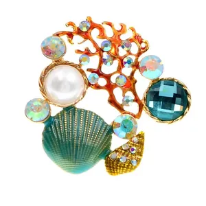 Detailed view of a vintage marine-themed shell and coral brooch with pearls and crystals
