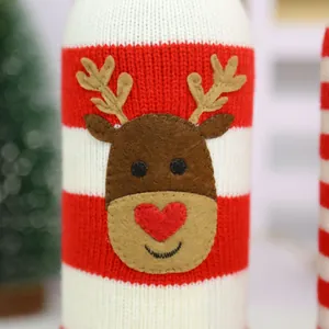 Close-up detail of knitted Christmas wine bottle cover with cute reindeer face applique