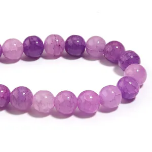 Primo piano dettagliato di perle di vetro crackle viola e rosa per progetti fai-da-te.