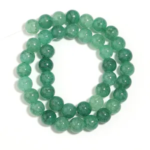 Primo piano di perle in vetro craquelé verde smeraldo per la creazione di gioielli fai da te