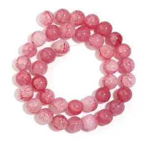 Dettaglio di perline rotonde in vetro craquelé rosa con trama floreale per gioielli fai da te