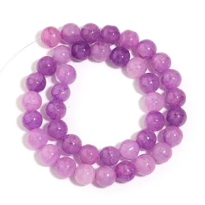 Dettaglio di perle tonde in vetro craquelé viola per creazione gioielli fai da te.