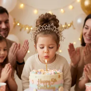 Adorable little girl blowing a birthday candle wearing a glittery star headband