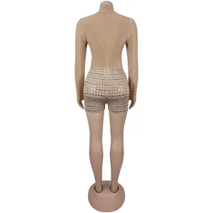 Back view of a sexy beige long-sleeve bodysuit featuring rhinestone studded shorts