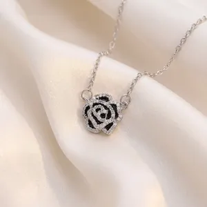 Elegante collar con colgante de rosa camelia y circonitas sobre fondo de seda blanca
