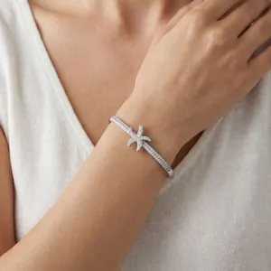 Primo piano dettagliato di un bracciale rigido a stella marina scintillante sul polso