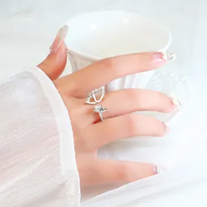 Detailed macro view of a silver hollow butterfly wing ring set with sparkling zircon stones
