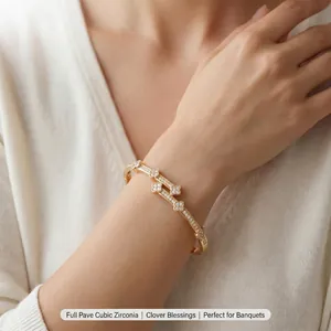 Élégant bracelet jonc en cuivre orné de fleurs en zircons sertis pavé sur le poignet d'un mannequin.