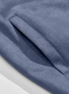Nahaufnahme der Seitentasche einer blauen Bomberjacke aus Wildleder mit feiner Naht.