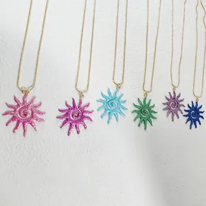 Gros plan de pendentifs soleil évidés colorés avec spirale et chaînes dorées