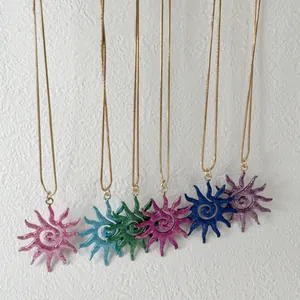 Vue détaillée de six colliers soleil évidés colorés avec motifs en spirale sur chaînes