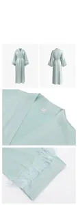 Detailed view of pale green satin bathrobe featuring luxury ostrich feather trim on cuffs