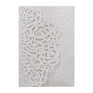 Gros plan d'une carte d'invitation argentée pailletée avec motif rose découpé au laser.