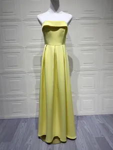 Robe de soirée longue jaune vif sans bretelles présentée sur un mannequin de couture.
