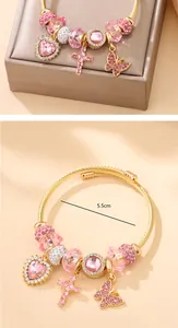 Détail d'un jonc en acier doré avec breloques en strass roses et diamètre de 5,5 cm
