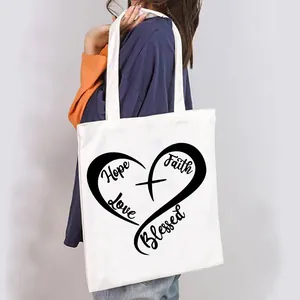 Close-up of a white canvas tote bag with heart-shaped Hope Love Faith Blessed print