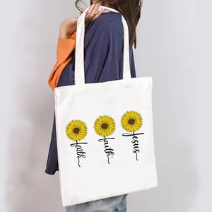Lifestyle shot of a woman carrying a white canvas tote bag with sunflower faith Jesus print.