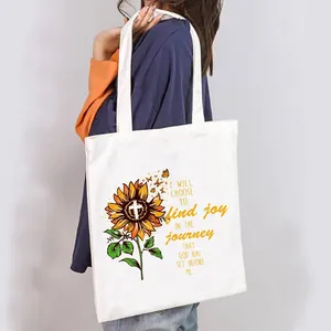Close-up of women's white canvas tote bag with sunflower and motivational Christian quote